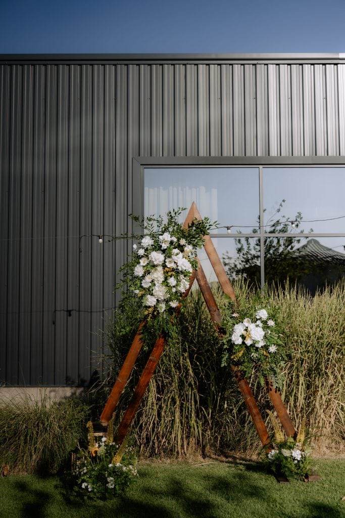 decor-nunta-exterior-arcada-aframe-flori-iasi.jpg Arcadă A-frame din lemn decorată cu flori, ceremonie de nuntă în aer liber, Iași