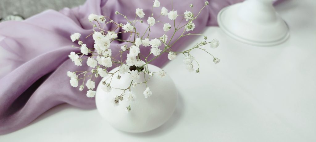 Vas alb cu gypsophila de nunta, pe voal lila, probă de decor în atelierul din Holboca, Iași
